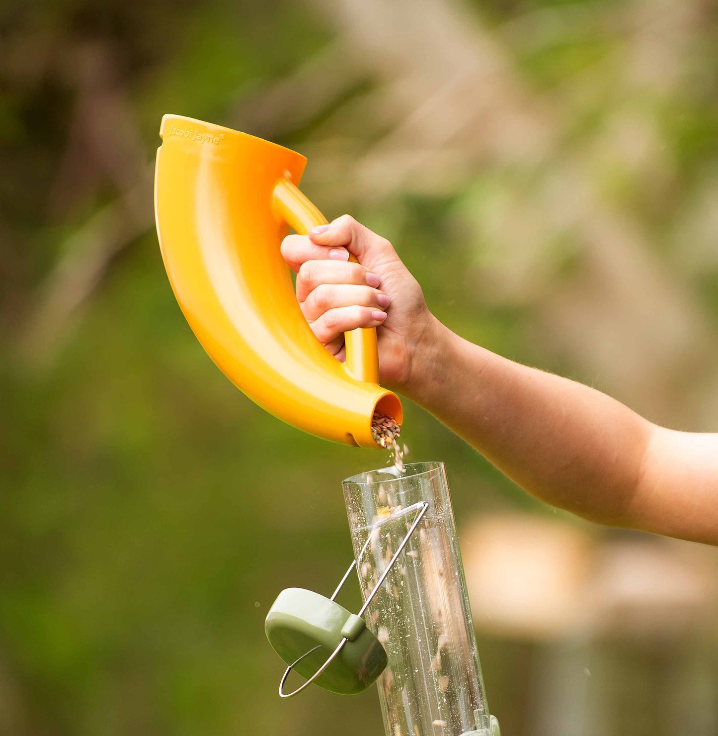 Scoopy bird feeding scoop pouring a seed mix or blend into a durable large bird feeder.