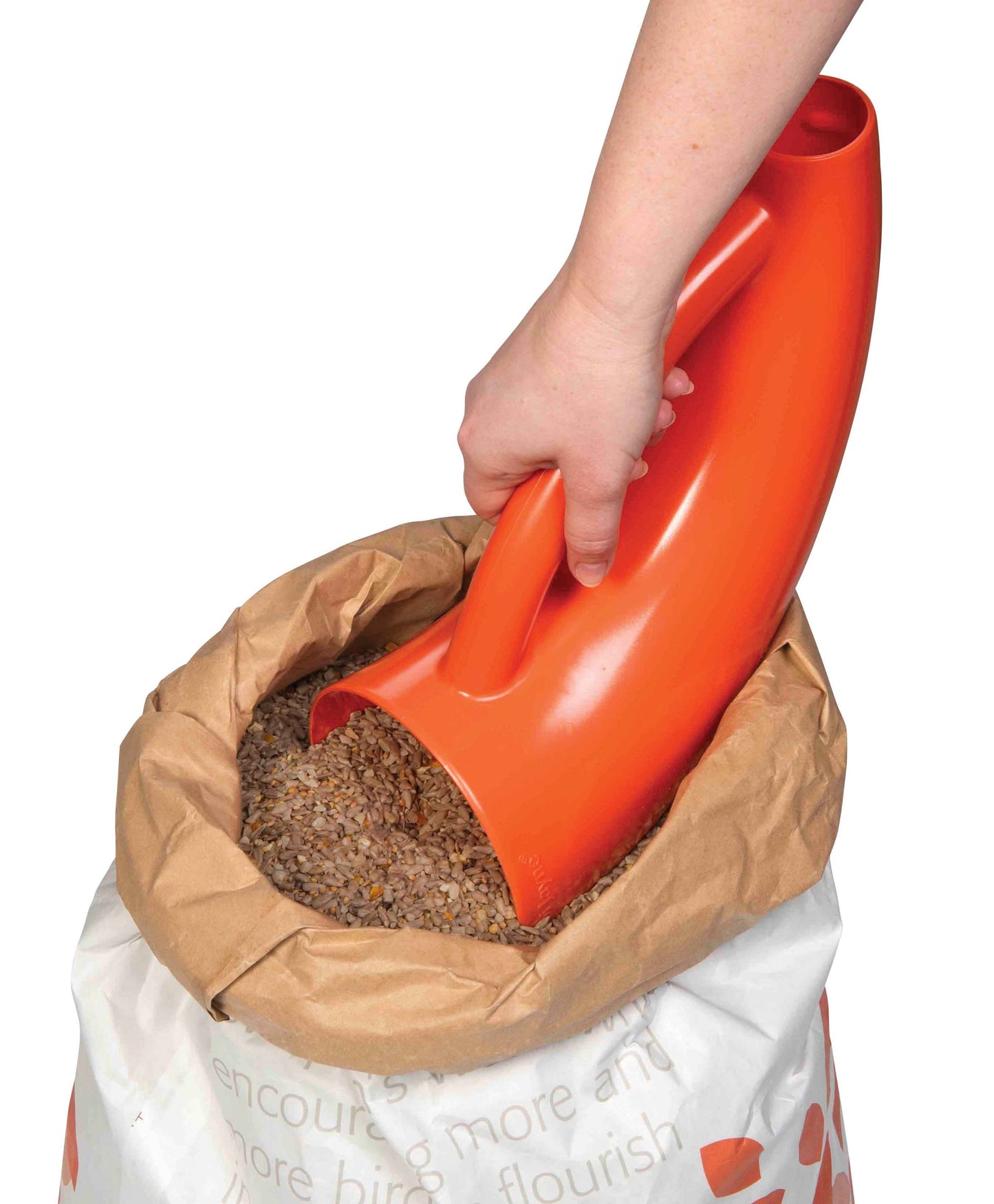 Scoop for bird seed collecting seed blend ready to pour into large bird feeder.